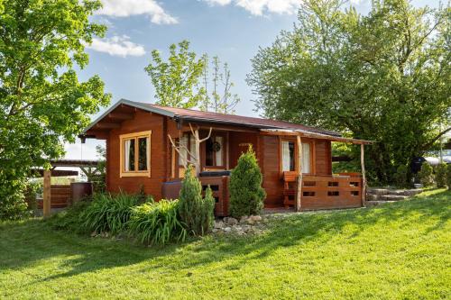 a small wooden house on a green lawn at Cozy wood hut on the farm in Třebívlice