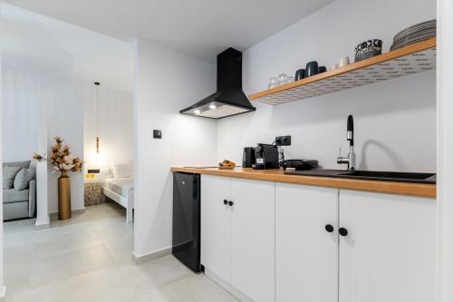 a kitchen with white cabinets and a counter top at Golden Bay in Agios Prokopios