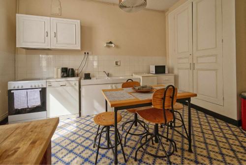 une cuisine avec une table et des chaises dans l'établissement Au pied de la tour Saint Antoine, à Loches