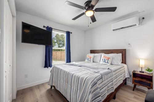 een slaapkamer met een bed met een plafondventilator bij Downtown Heights Flat Games TVs WiFi Pets in Houston