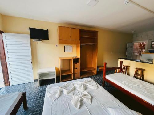a room with two beds and a kitchen at Pousada Caraguá in Caraguatatuba
