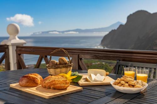 a table with bread and baskets of food and orange juice at Banana Garden Suites in Hermigua