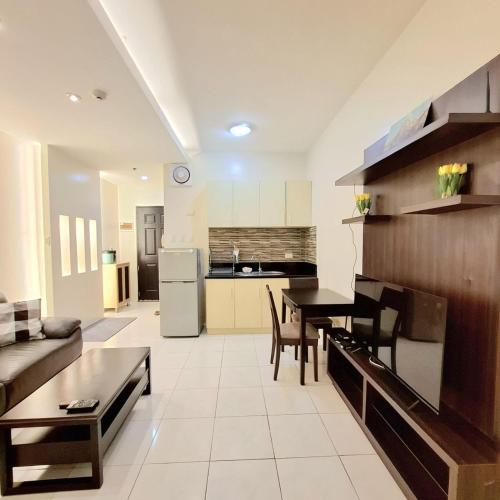 a kitchen and living room with a table and a couch at BREATHTAKING BAYVIEWS - 1-5 BR Luxury and Superior Condos with Panoramic Bay Views, Balcony, Gym, Pool & Netflix - Housekeeping Available - in Manila
