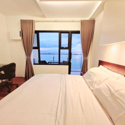a bedroom with a bed and a large window at BREATHTAKING BAYVIEWS - 1-5 BR Luxury and Superior Condos with Panoramic Bay Views, Balcony, Gym, Pool & Netflix - Housekeeping Available - in Manila