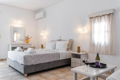 a bedroom with a bed and a table with wine glasses at Golden Bay in Agios Prokopios
