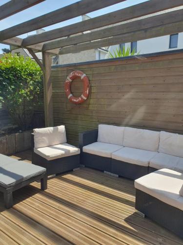 une terrasse avec deux canapés et une pergola dans l'établissement Maison Les Aygals 300 m de la plage, 3 suites parentales, à Saint-Pierre-Quiberon