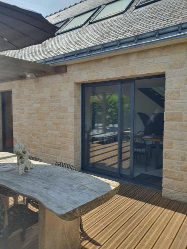 un patio avec un banc en pierre sur une terrasse en bois dans l'établissement Maison Les Aygals 300 m de la plage, 3 suites parentales, à Saint-Pierre-Quiberon