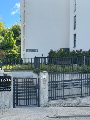 a gate with a sign in front of a building at Navy Blue Apartment in Gdynia