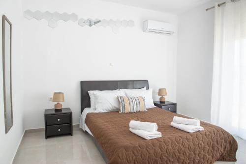 アルハンゲロスにあるKaterina family Apartmentのベッドルーム1室(大型ベッド1台、白いタオル2枚付)