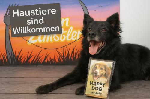 a dog is laying next to a happy dog book at Zum Obstler - Gaststätte und Pension in Gera