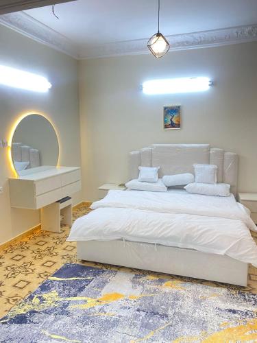 a bedroom with a large white bed and a mirror at نزل القمريه in Taif