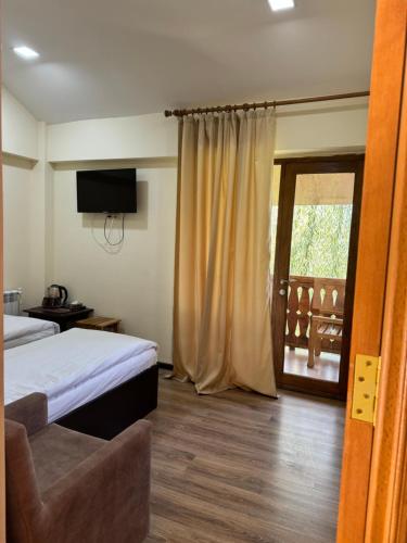 a bedroom with a bed and a sliding glass door at Verin Tun in Dilijan