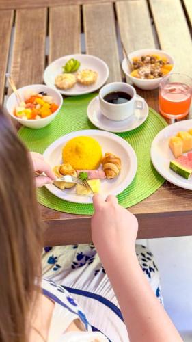 a girl sitting at a table with a plate of food at Portal Da Praia Hotel in Fortaleza