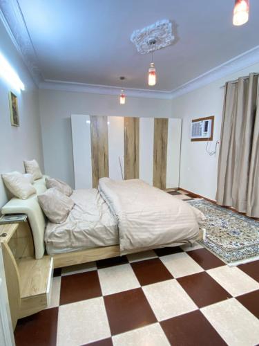 a bedroom with a bed and a checkered floor at نزل القمريه in Taif