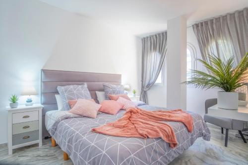 a bedroom with a bed with an orange blanket on it at Alma's Dream Estepona in Estepona