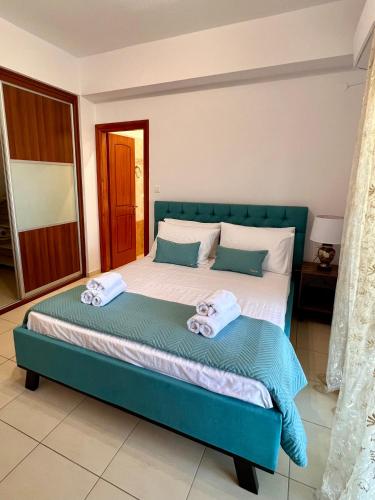 a bedroom with a blue bed with towels on it at Golden Sunset Villa Skiathos in Skiathos Town