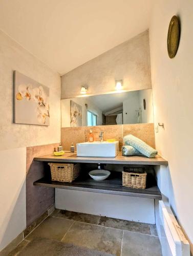 une salle de bain avec un lavabo et un miroir dans l'établissement Gîte au Pont du Gard, à Castillon-du-Gard