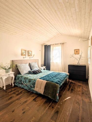 une chambre avec un grand lit avec un plafond en bois dans l'établissement Gîte au Pont du Gard, à Castillon-du-Gard
