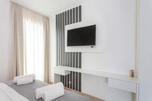 a bedroom with a tv on a wall with a bed at Sunset Split Rooms in Podstrana