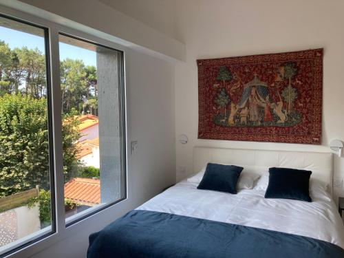 une chambre avec un lit et une grande fenêtre dans l'établissement Villa Etche Ona, chambre chez l'habitant, à Biarritz