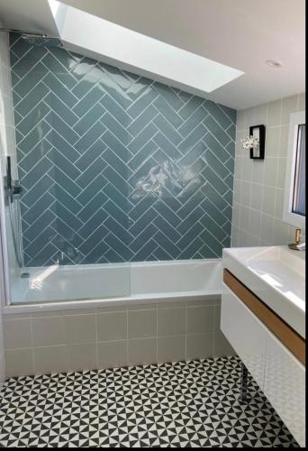 une salle de bain avec baignoire et sol carrelé dans l'établissement Villa Etche Ona, chambre chez l'habitant, à Biarritz