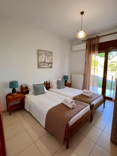 a bedroom with two beds and a window at Golden Sunset Villa Skiathos in Skiathos Town