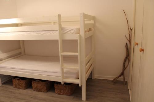 un lit superposé blanc dans une chambre avec des paniers dans l'établissement Appt 2 piècesPORT LA NOUVELLE PN550-018, à Port-la-Nouvelle