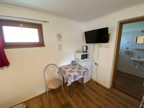 a small room with a table and a microwave at Eszter Vendégház Harta in Harta