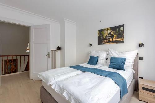 une chambre avec un grand lit blanc avec des oreillers bleus dans l'établissement Apparemment neuf entrée indépendante, à Hœrdt