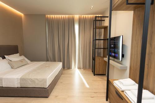 a hotel room with a bed and a television at South Inn Hotel in Vlorë
