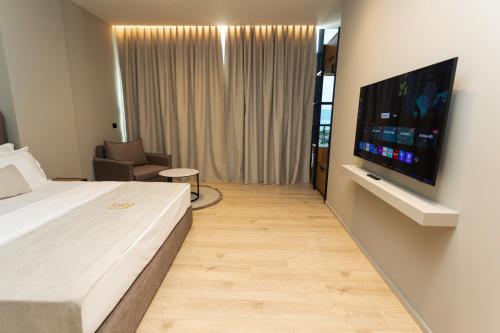 a hotel room with a bed and a flat screen tv at South Inn Hotel in Vlorë