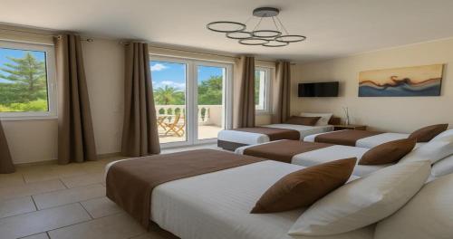 a hotel room with four beds and a window at Villa Small Paradise private pool, jacuzzi, BBQ, complete privacy in Ialyssos