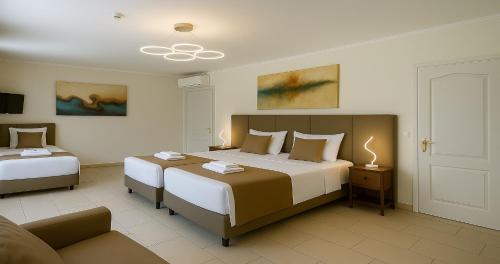 a bedroom with two beds and a couch at Villa Small Paradise private pool, jacuzzi, BBQ, complete privacy in Ialyssos