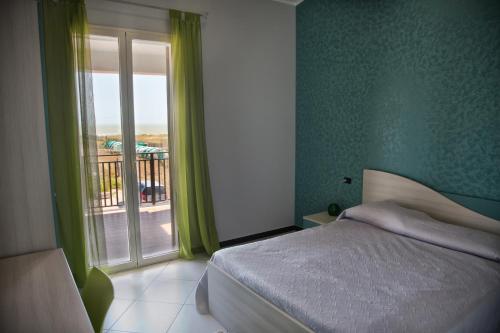 1 dormitorio con 1 cama y ventana con balcón en B&B Villa Virginia, en Licata