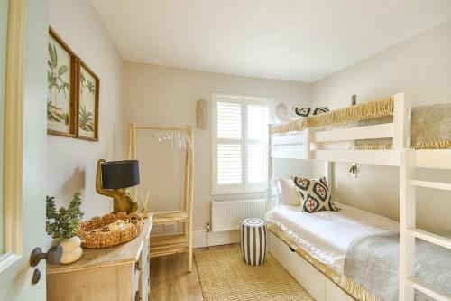 una camera con due letti a castello e una finestra di The Salt House - sleeps 12 & 3 mins to beach a Melcombe Regis
