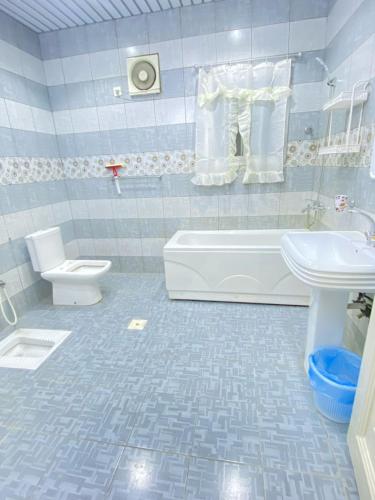 a bathroom with a tub and a toilet and a sink at نزل القمريه in Taif