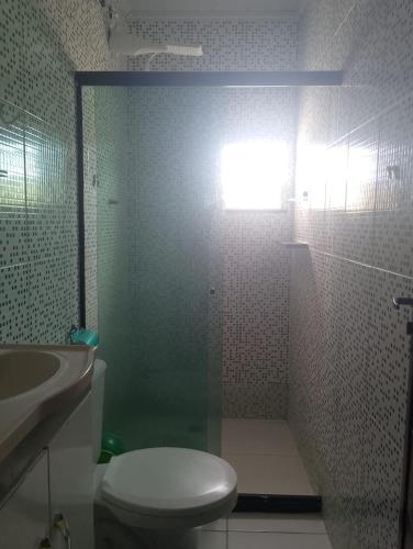 a bathroom with a shower with a toilet and a sink at Kitnet PRAIA GRANDE in Arraial do Cabo