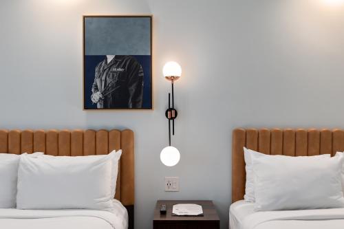 a bedroom with two beds and a picture on the wall at The Guild Hotel San Diego Downtown, a Marriott Tribute Portfolio Hotel in San Diego