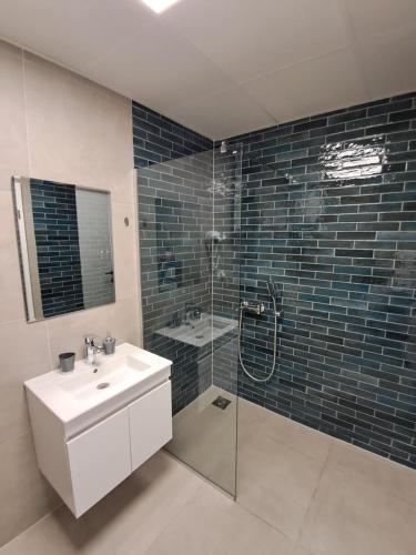 a bathroom with a sink and a shower with a shower at Water's Edge Apartment Ohrid in Ohrid