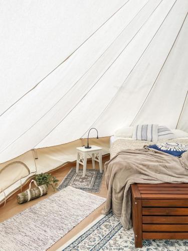 a bedroom with a tent with two beds and a table at Glamping Kalhagen in Vangsbygd