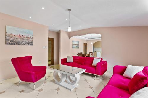 a living room with pink furniture and a table at Apartments Dončić in Kotor