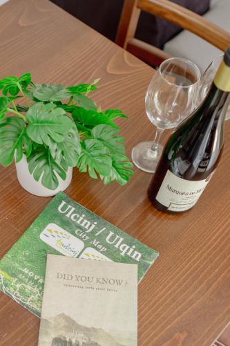 a bottle of wine and a potted plant on a table at Medo in Ulcinj