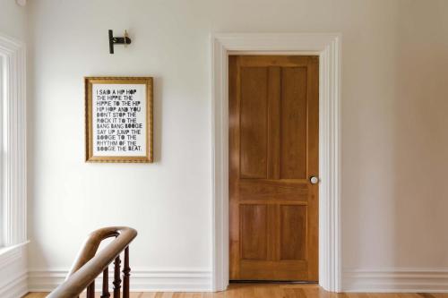 a room with a wooden door and a picture on the wall at SquirrelHaus PEC in Hillier