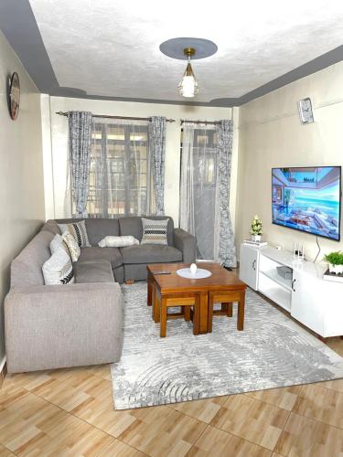 a living room with a couch and a table at The Kulta Spot Executive Living in Thika