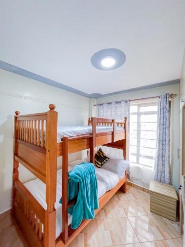 two bunk beds in a room with a window at The Kulta Spot Executive Living in Thika