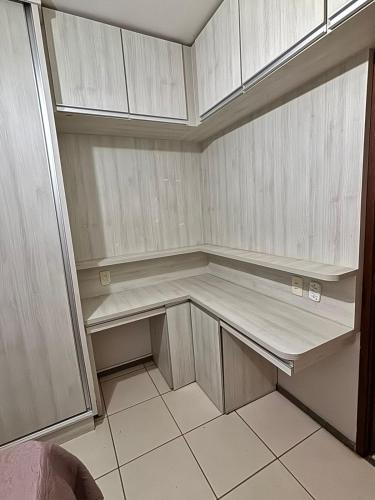 a walk in closet with white cabinets and tile floor at Excelente e amplo Apto 2 Q in Araguari