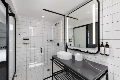 a bathroom with a sink and a mirror at The Guild Hotel San Diego Downtown, a Marriott Tribute Portfolio Hotel in San Diego