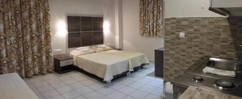 - une chambre avec un lit et un lavabo dans l'établissement Pallada Hotel, à Agia Galini
