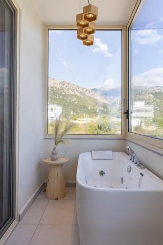 a bath tub in a bathroom with a large window at Dimitri Hotel in Himare