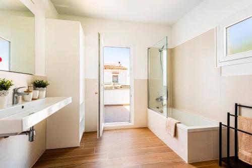 a white bathroom with a sink and a shower at Villa Tres Arcos by Villa Plus in Cala en Blanes